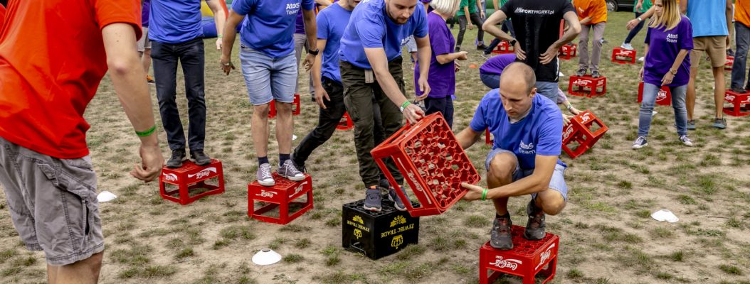 Mężczyźni walczą w konkurencji na plenerowej imprezie integracyjnej.