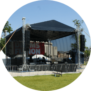 Zadaszona scena plenerowa z oświetleniem i nagłośnieniem na festiwalu muzycznym.