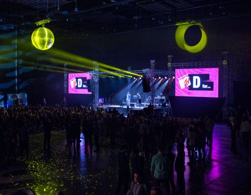 Ludzie stoją przed sceną na imprezie integracyjnej.