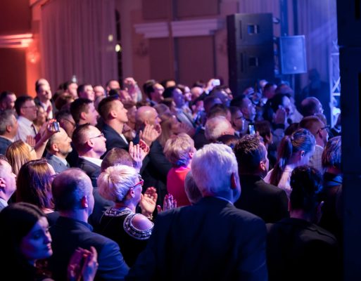 Publiczność słucha koncertu zorganizowanego z okazji jubileuszu firmowego.