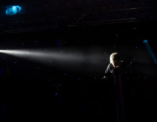 Mężczyzna gra na klawiszach na scenie w czasie koncertu na evencie firmowym.