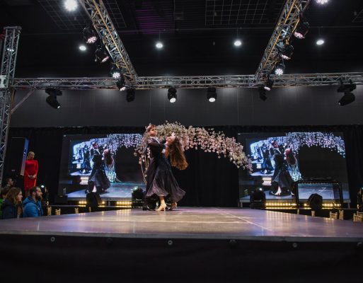 Para taneczna daje występ artystyczny na scenie na targach ślubnych.