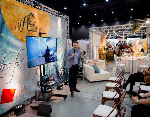 Mężczyzna prowadzi pokaz przy telebimie na targach.