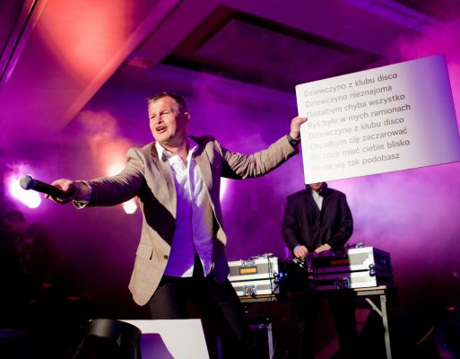 Konferansjer prowadzi karaoke na prywatnej imprezie okolicznościowej.