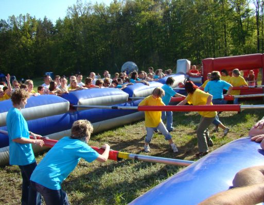 Drużyna rozgrywa mecz w dmuchane piłkarzyki w ramach atrakcji na firmowej imprezie integracyjnej.