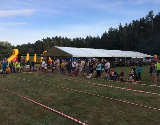 Impreza firmowa na polanie z namiotem, dmuchańcami i torami do konkurencji teambuildingowych.