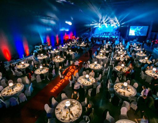 Niebiesko-czerwona scena i sala zaaranżowane na bankiet firmowy.