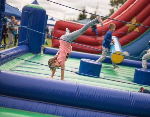 Dzieci bawią się na dmuchańcach i innych atrakcjach w trakcie festynu.