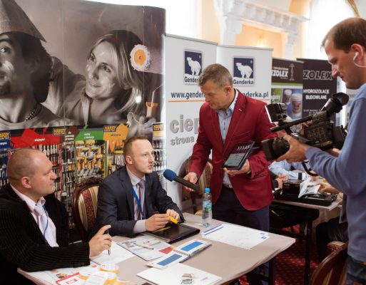 Konferansjer przeprowadza wywiad z przedstawicielami na targach budowlanych.