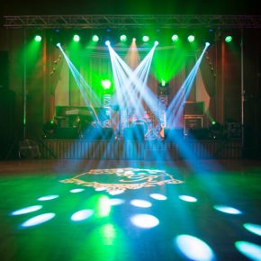 Kolorowe oświetlenie efektowe na parkiecie i scenie z instrumentami.